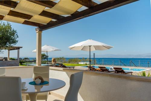 a patio with a table and chairs and the ocean at Villa Mis in Supetar