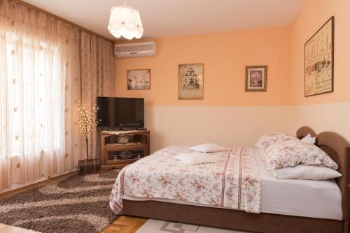 Schlafzimmer mit einem Bett und einem Flachbild-TV in der Unterkunft Sibenik City Center Apartment in Šibenik