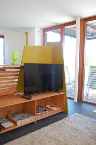 ein Wohnzimmer mit einem Flachbild-TV auf einem hölzernen Entertainment-Center in der Unterkunft "An der Wasserstraße" in Malchow