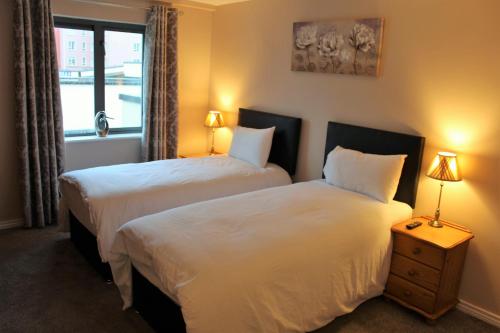 a hotel room with two beds and a window at Wild Atlantic Accommodation 18 Glenveagh Court in Letterkenny