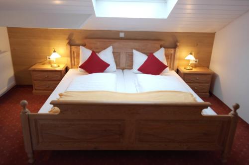 a bedroom with a large bed with red pillows at Landhotel Windlicht in Krombach