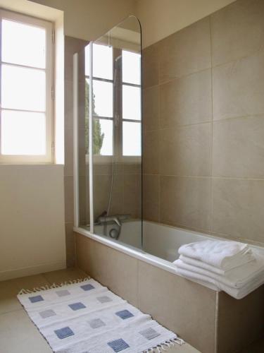 une salle de bain avec une baignoire et un miroir dans l'établissement Le Mas du Rocher, à Mérindol-les-Oliviers