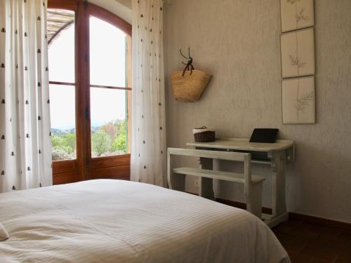 a bedroom with a bed and a desk with a laptop at Le Mas du Rocher in Mérindol-les-Oliviers
