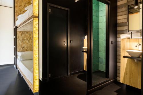 baño con puerta negra y lavamanos en Bastardo Hostel, en Madrid