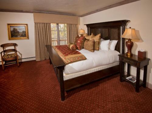 a bedroom with a bed and a table and a window at The Arrabelle at Vail Square, a RockResort in Vail