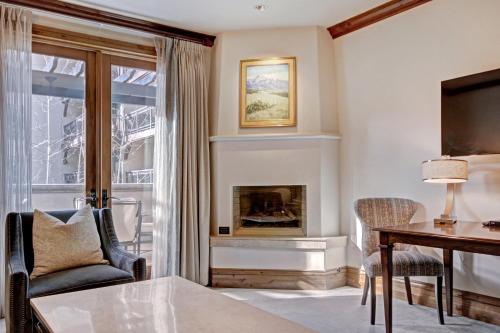 a living room with a desk and a fireplace at The Arrabelle at Vail Square, a RockResort in Vail