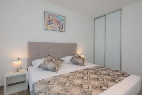 a bedroom with a large white bed with two pillows at Apartments Alba in Slatine