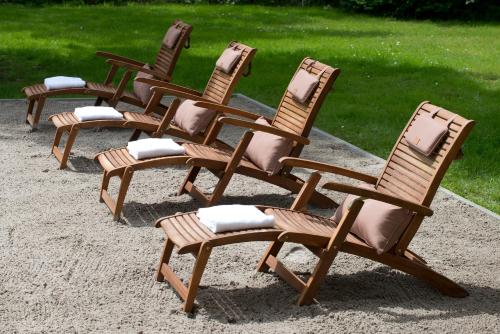 a row of rocking chairs sitting in the sand at Mercure Hotel Saarbrücken Süd in Saarbrücken