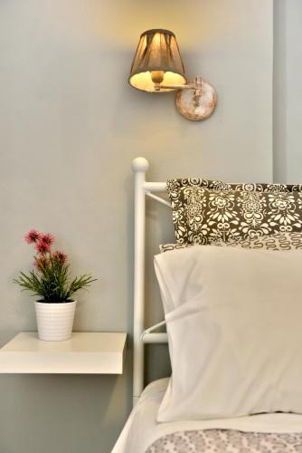 a bedroom with a bed with a lamp and a plant at Guesthouse Corali in Hydra