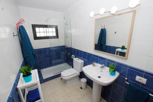 Un baño azul y blanco con inodoro y lavabo. en Casa Pura, en Arrieta