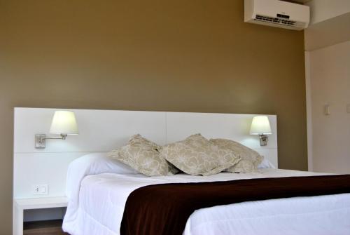 a bedroom with a white bed with two pillows at Hotel Castilla in Punta del Este