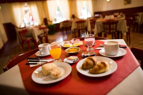 a table with plates of food and drinks on it at Casablanca Hotel & Spa in Santa Rosa de Calamuchita
