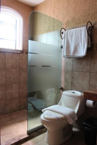 a bathroom with a toilet and a glass shower at Parador Margarita in San Cristóbal de Las Casas