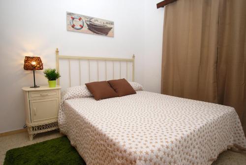 Un dormitorio con una cama y una mesa con una lámpara. en Casa Pura, en Arrieta