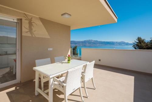 a dining room with a table and chairs on a balcony at Apartments Alba in Slatine