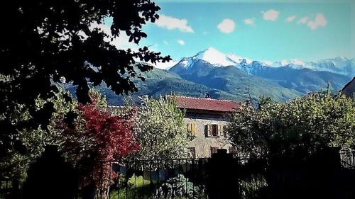 um edifício com uma montanha ao fundo em Il Giardino dei Merli em Bussoleno