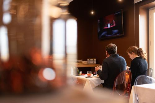 two people sitting at a table in a restaurant at Hotel Porta Reale in Noto