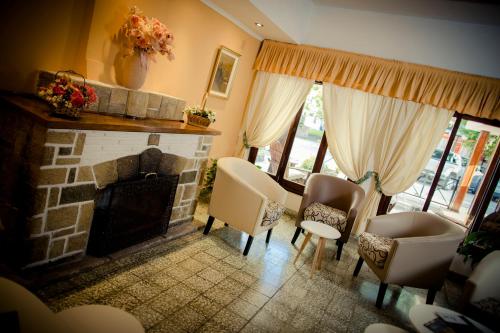 a living room with a fireplace and chairs at Casablanca Hotel & Spa in Santa Rosa de Calamuchita