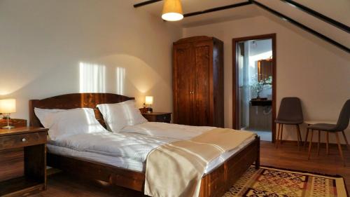 una camera da letto con un letto grande con testiera in legno di Casa Badea a Rîu Alb