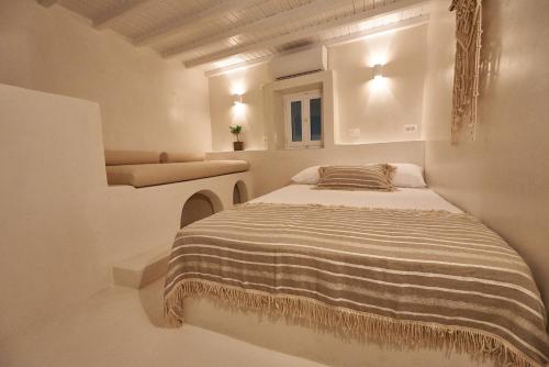 a bedroom with a bed in a white room at Blanco Rooms Mykonos in Mikonos