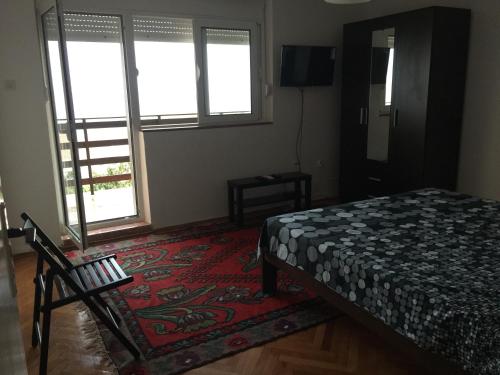 a bedroom with a bed and a rug and two windows at Poborska Villa in Ulcinj