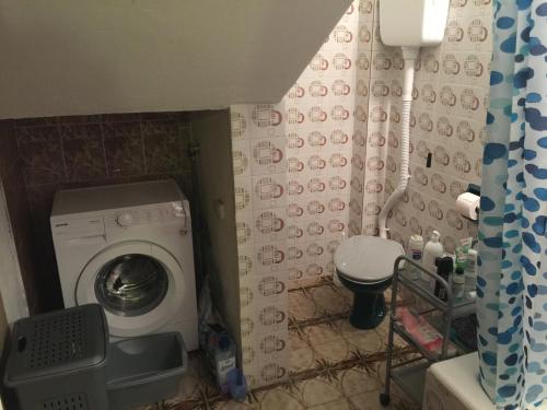 a small bathroom with a washing machine and a toilet at Poborska Villa in Ulcinj