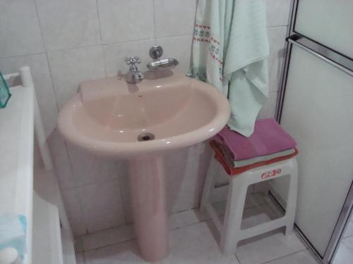 um lavatório branco na casa de banho com um chuveiro em Chalé Suiço de Campos do Jordão em Campos do Jordão