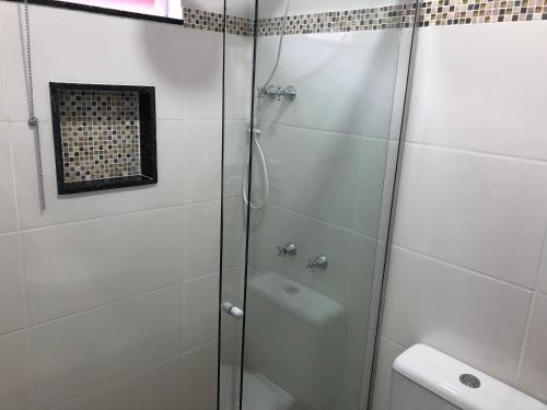 a shower with a glass door in a bathroom at Pousada Xero in Capitólio