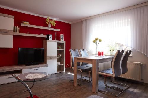 uma sala de estar com uma mesa e cadeiras e uma televisão em Ferienhaus Carola em Lübben