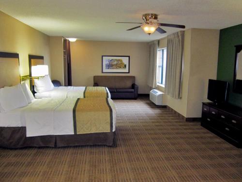 a hotel room with a bed and a television at Extended Stay America Suites - Detroit - Metropolitan Airport in Romulus