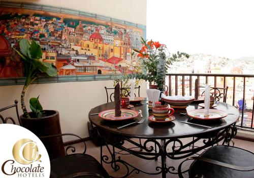 a table in a balcony with a painting on the wall at Hotel Chocolate Tradicional in Guanajuato