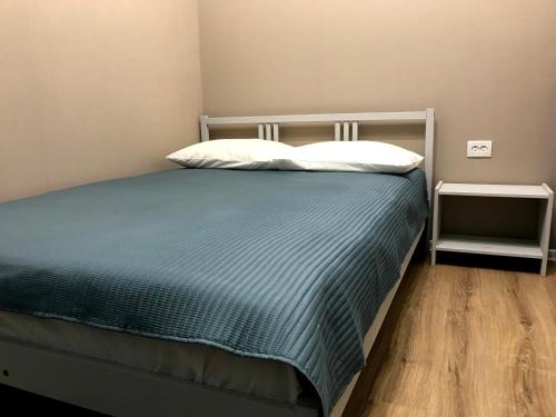 ペンザにあるАпартаменты Бизнесのベッドルーム1室(青い毛布と白い枕のベッド1台付)
