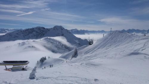a snow covered mountain with people standing on a ski slope at Apart Lechtraum in Stanzach
