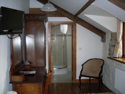 a room with a tv and a chair in a room at The Barn B&B in Margam