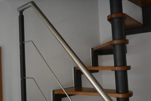 a metal and wooden spiral staircase in a room at San Biagio Materapartment in Matera