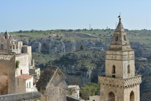 a church and a tower with a view of a canyon at San Biagio Materapartment in Matera
