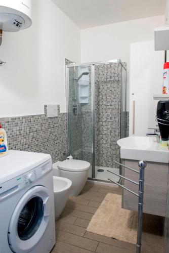 a bathroom with a washing machine and a toilet at Castelsardo Miramare 10 - 6 posti in Castelsardo