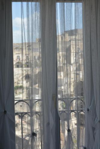 a room with a window with white curtains at San Biagio Materapartment in Matera