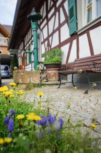 a bench and flowers in front of a building at Apartment Kirschblüte in Appenweier