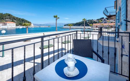 a table on a balcony with a view of the water at Villa Riva in Jelsa