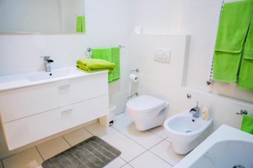 a white bathroom with a toilet and a sink at Angolo Paradiso - Lago di Como in Valbrona