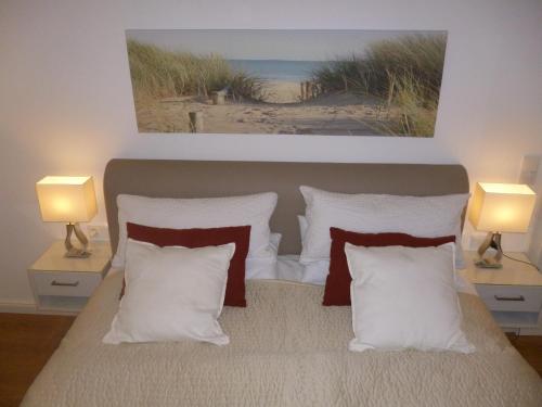 グロース・シュヴァンセにあるLandhaus 4 Jahreszeitenのベッドルーム1室(白い枕とランプ2つ付)