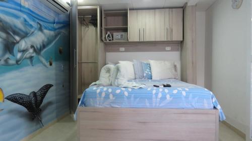 a bedroom with a bed with a dolphin painting on the wall at Posada J&J Forbes - 1 in San Andrés