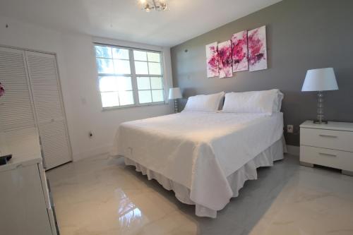 1 dormitorio con cama blanca y ventana en Yacht Club at Aventura 1 Bd 1 Bth Brand New, en Aventura