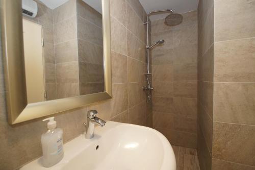 Un baño con lavabo, espejo y ducha. en Adriatic Villa Lumbarda, en Lumbarda