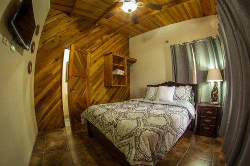 um quarto com uma cama e uma parede de madeira em Villas Fernanda #2 em La Fortuna