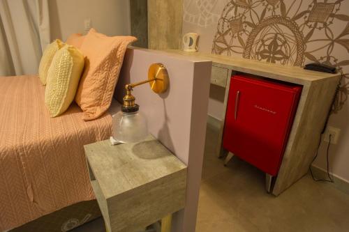 a bedroom with a bed and a table with a lamp at Pousada Renda do Mar in Morro de São Paulo