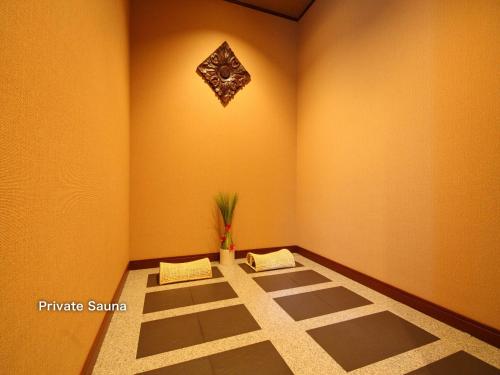 Un rincón de una habitación con una planta en la pared. en Hotel Balian Resort Tomei Kawasaki I.C., en Kawasaki