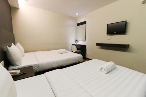 a hotel room with two beds and a flat screen tv at Hotel 99 Bandar Klang (Meru) in Klang