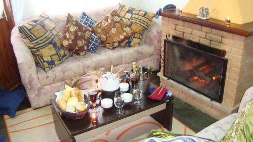 a living room with a couch and a fireplace at Chalé Suiço de Campos do Jordão in Campos do Jordão